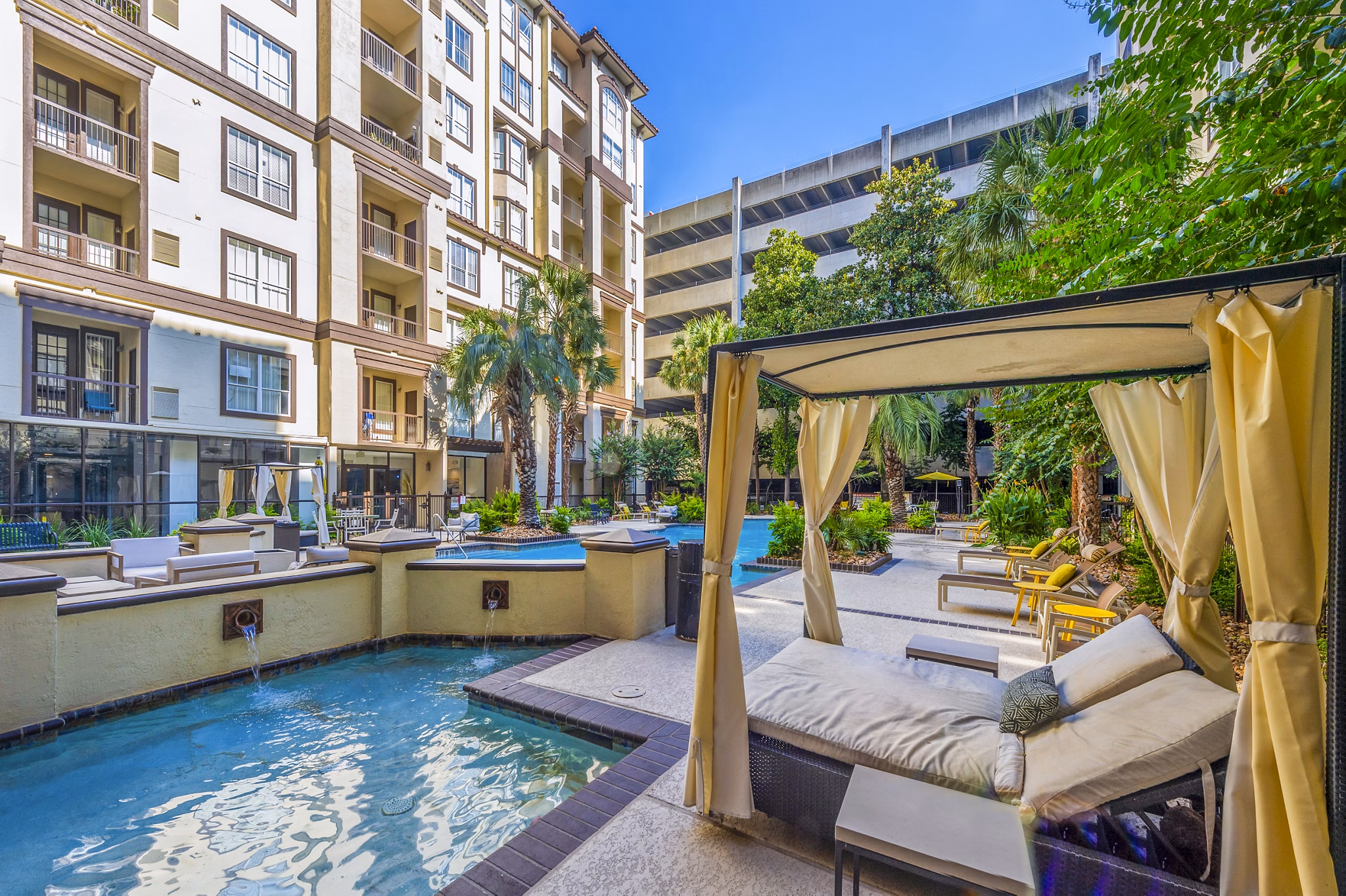 Resort-style pool surrounded by lush greenery at 4001 Midtown Apartments, offering a luxurious relaxation space for residents