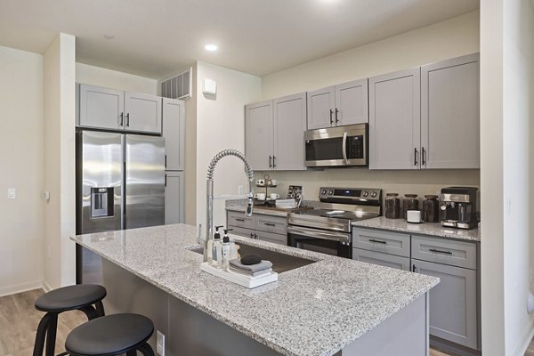 Kitchen with stainless appliances and quartz countertops in Prose Desert River Apartments