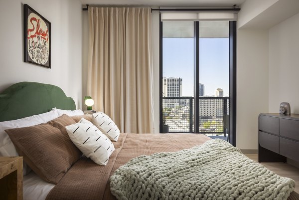 Modern bedroom with large windows at The Waller Apartments, a luxury living option by Greystar in vibrant downtown