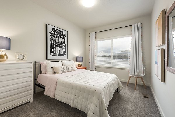 Bedroom featuring a king-size bed and stylish decor at H2O Townhomes Apartments