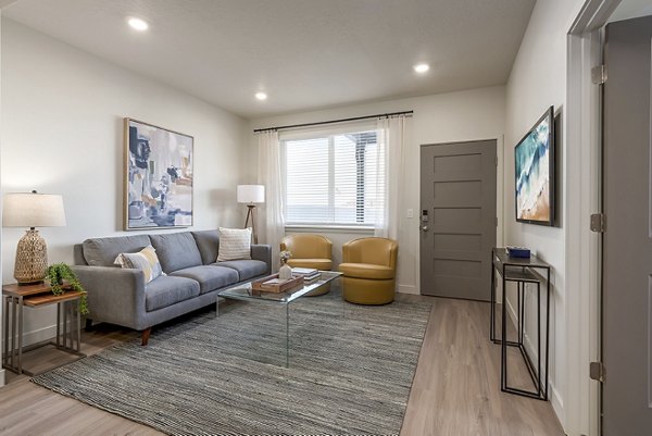 Spacious living room with modern decor and large windows in H2O Townhomes Apartments