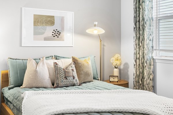 Contemporary bedroom featuring plush bedding and stylish decor at Mira Crystal Lake Apartments