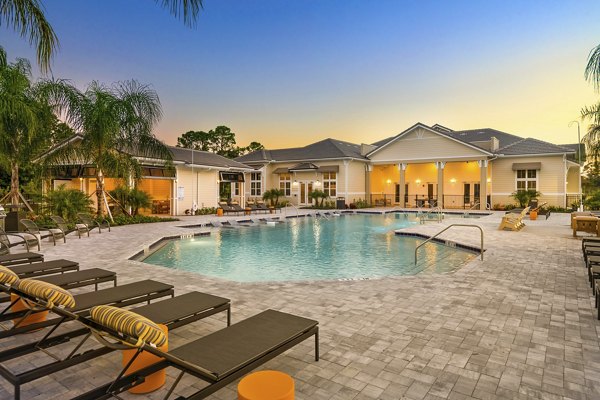 Resort-style pool with lounge areas at Mira Crystal Lake Apartments, a Greystar luxury community