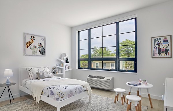 Cozy bedroom with modern decor and soft lighting at BELA Apartments, luxury living in Jersey City