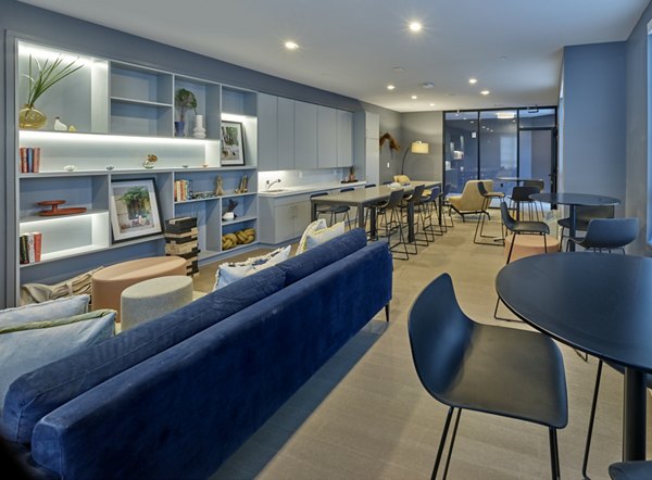 Clubhouse with modern design and ample seating at BELA Apartments, ideal for social gatherings and resident events