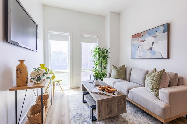 Spacious living room with modern decor and natural light at The Bedford Apartments