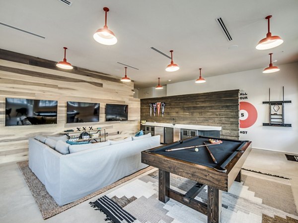 Clubhouse game room with pool table and lounge seating at Vecina Apartment Villas