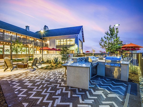 Grill area with cozy patio seating at Vecina Apartment Villas