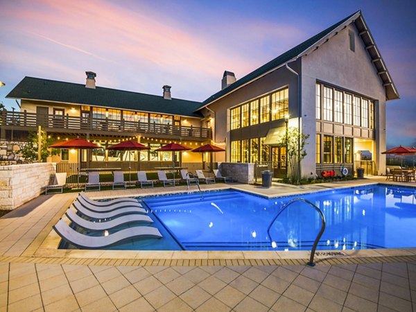 Tranquil outdoor pool with resort-style seating at Vecina Apartment Villas