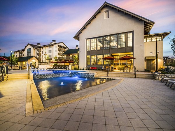 Luxurious pool at Vecina Apartment Villas featuring comfortable lounge chairs and lush landscaping for a relaxing resident experience