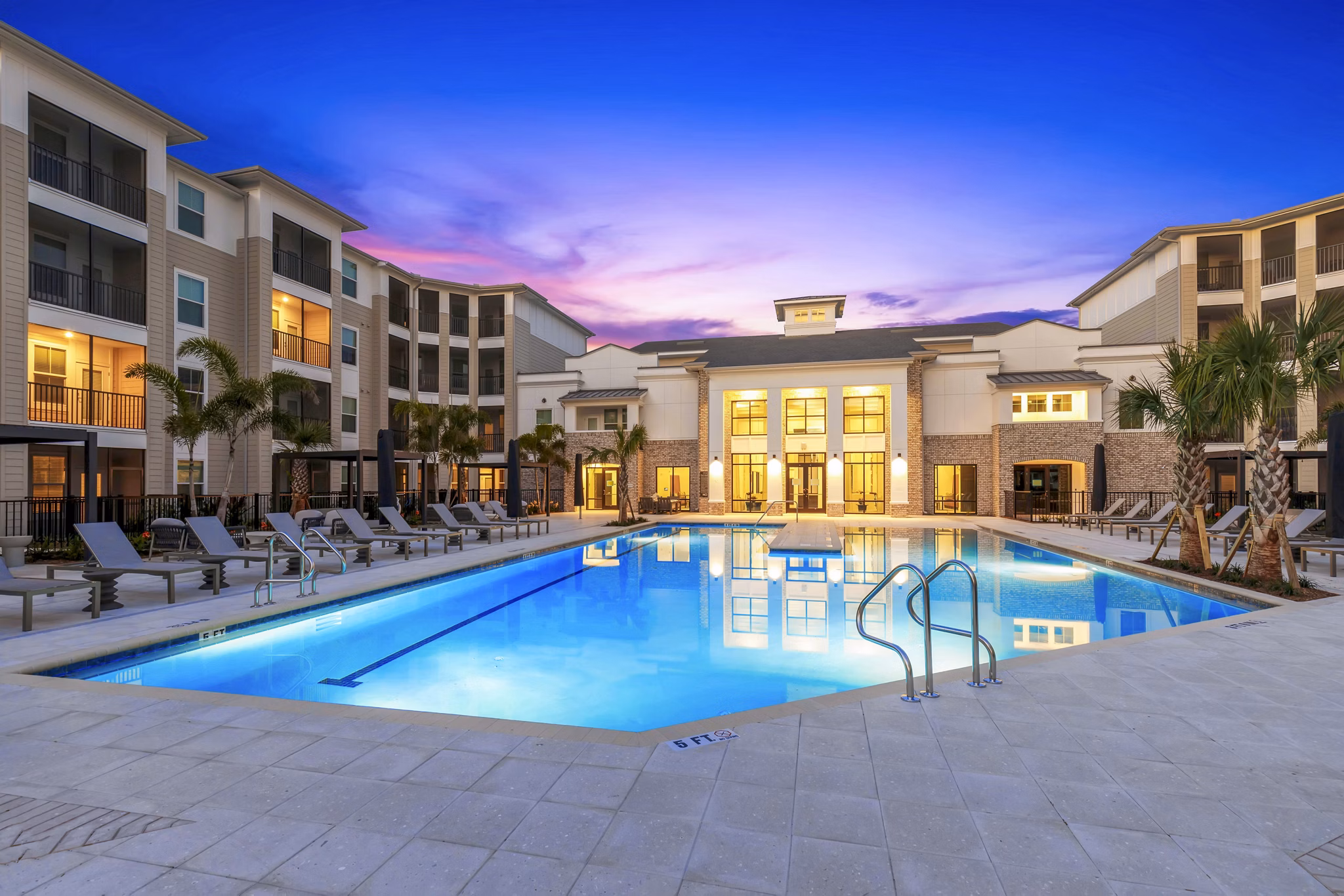Resort-style pool at Marlowe South Tampa Apartments, featuring lounge seating and lush landscaping