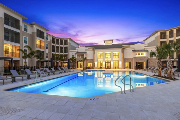 Resort-style pool at Marlowe South Tampa Apartments, featuring lounge seating and lush landscaping