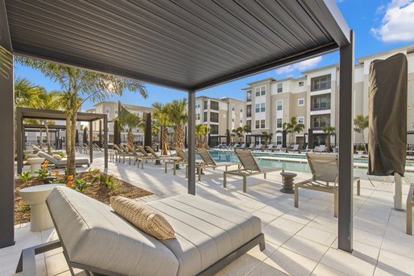 Milano Apartments: Serene courtyard with lush greenery and seating in a luxury community