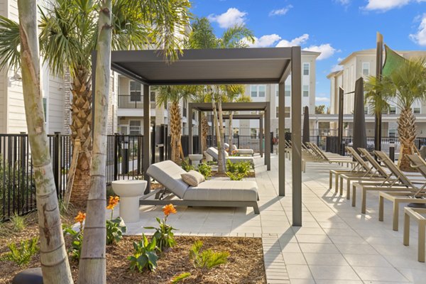 Tranquil courtyard featuring lush landscaping and seating area at Milano Apartments