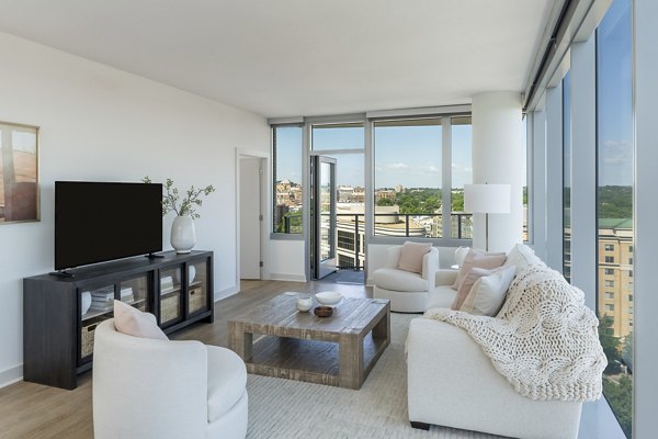 Living room with cozy sectional sofa and modern decor at The Commodore Apartments