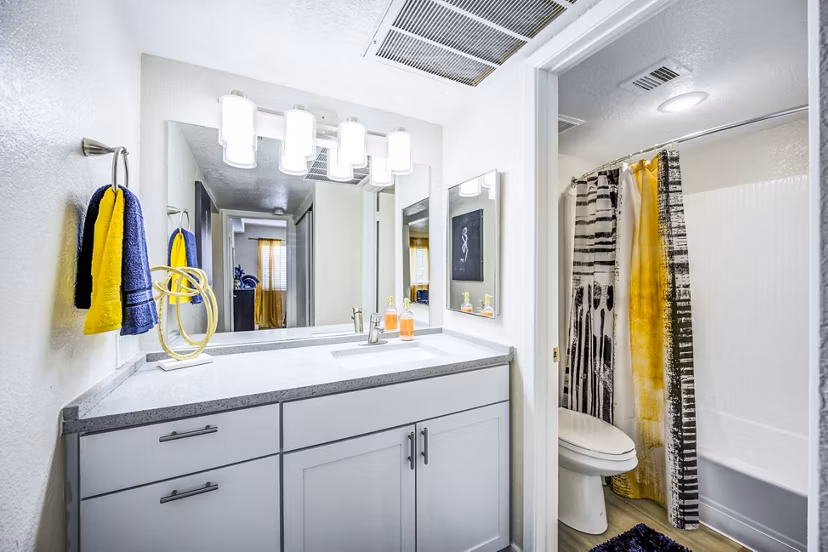 Modern bathroom with sleek fixtures and a large mirror at Monterey Village Apartments