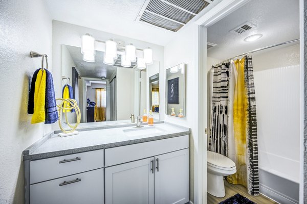 Modern bathroom with sleek fixtures and a large mirror at Monterey Village Apartments