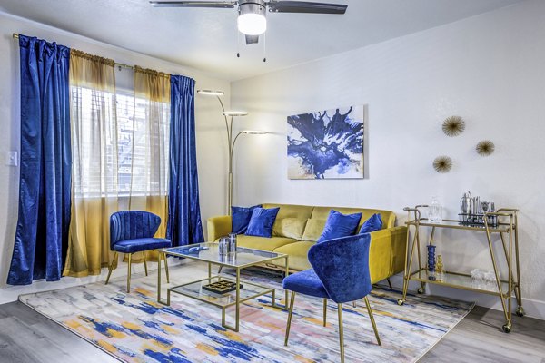 Spacious living room with modern decor and large windows in Monterey Village Apartments, a luxury property by Greystar