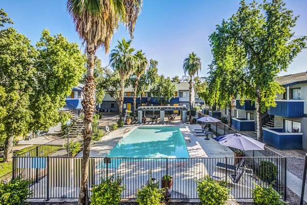 Serene outdoor pool surrounded by lush greenery at Monterey Village Apartments