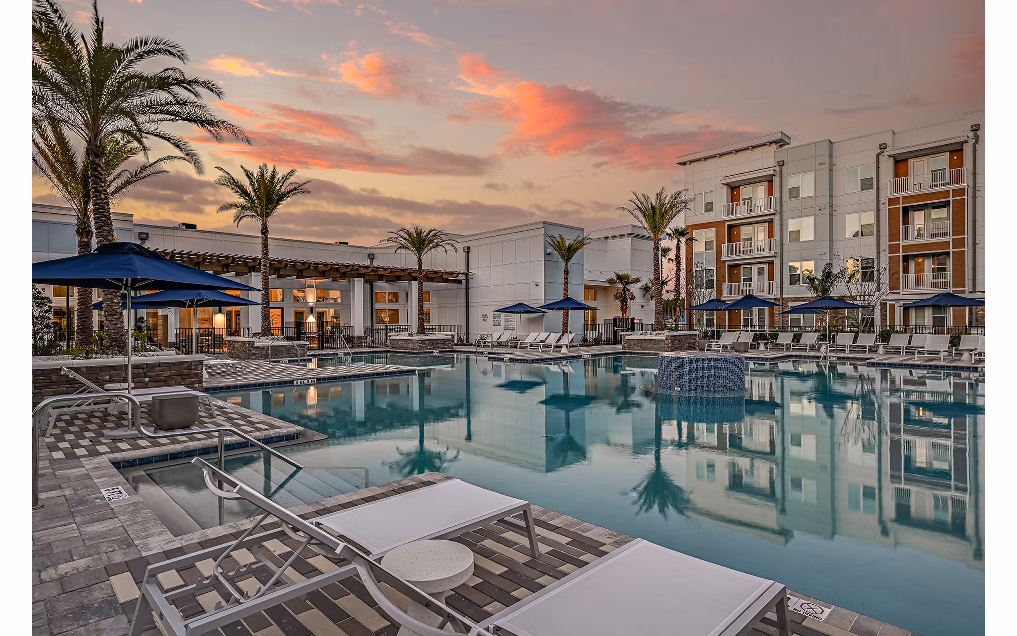 Aspire at Silverleaf Apartments: Modern pool with lounge chairs and greenery