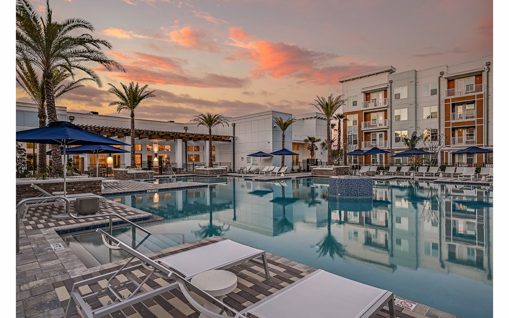 Aspire at Silverleaf Apartments: Modern pool with lounge chairs and greenery