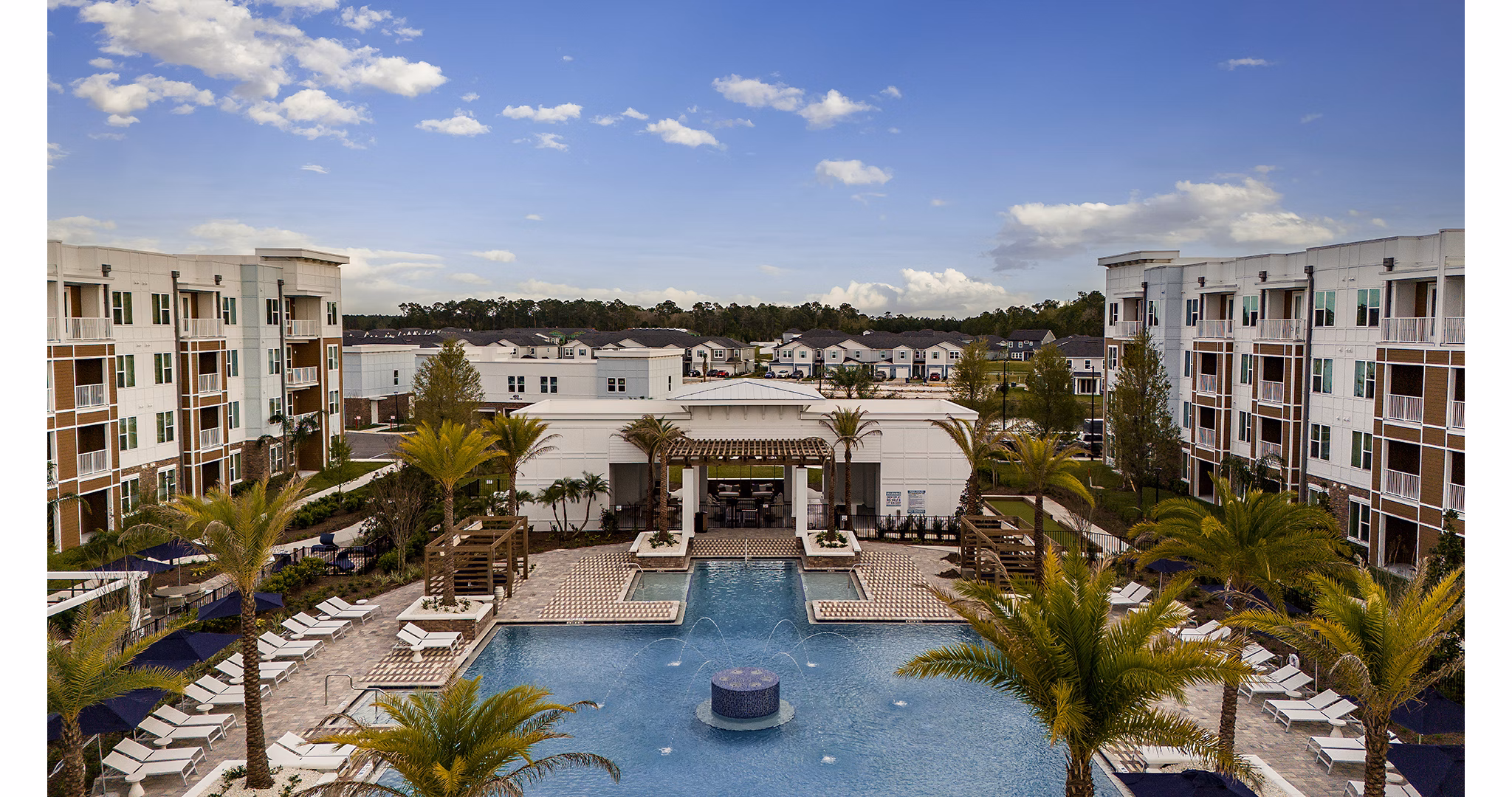 Spacious outdoor pool area at Aspire at Silverleaf Apartments featuring lush landscaping and modern lounge chairs for relaxation