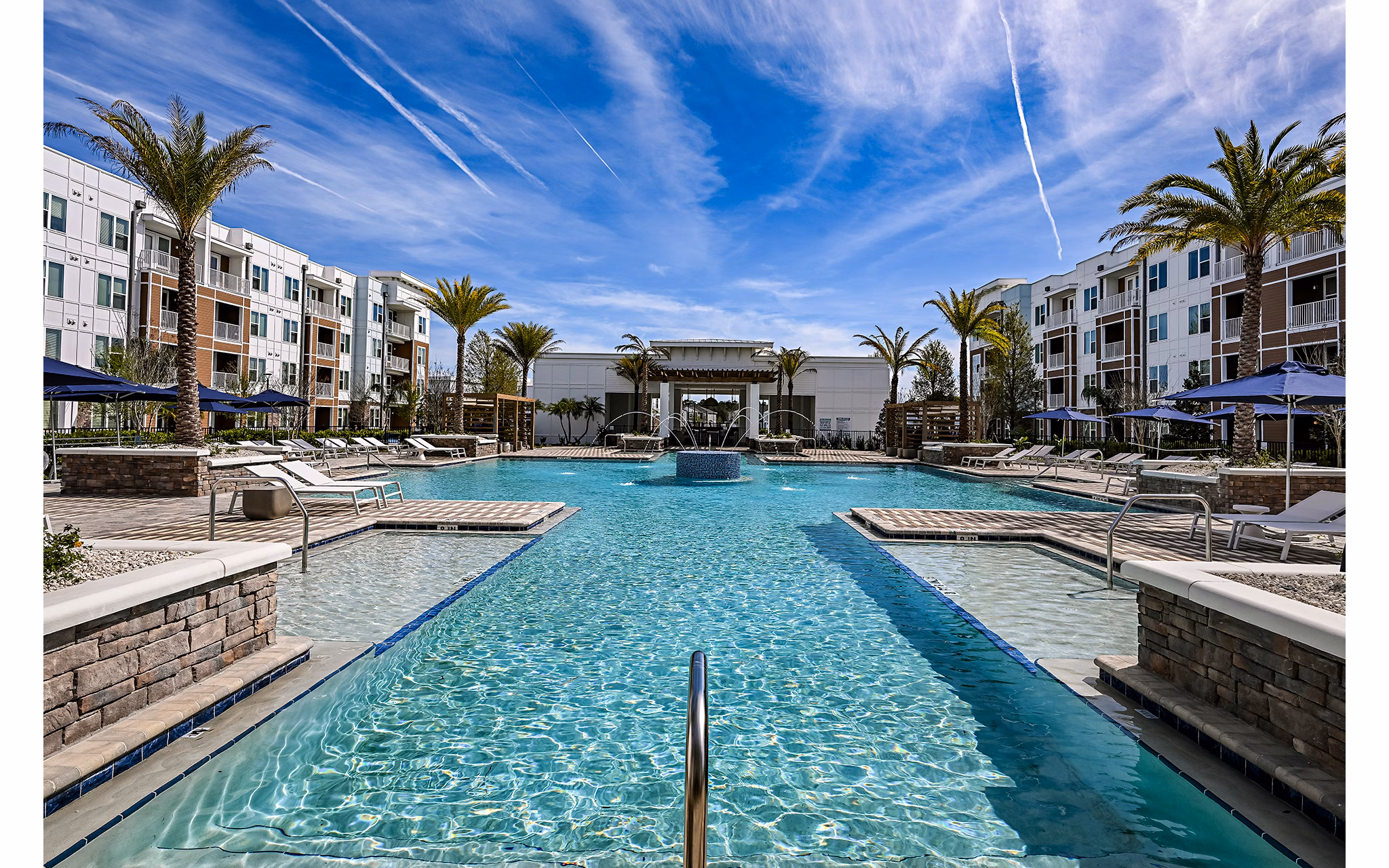 Resort-style pool with lounge chairs at Aspire at Silverleaf Apartments