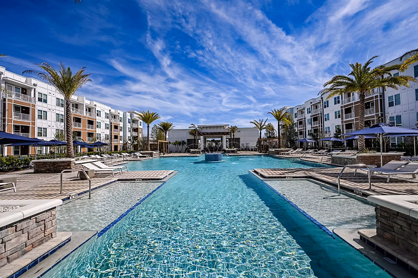 Modern pool area with lounge chairs and lush landscaping at Aspire at Silverleaf luxury apartments