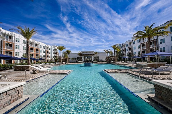 Modern pool area with lounge chairs and lush landscaping at Aspire at Silverleaf luxury apartments