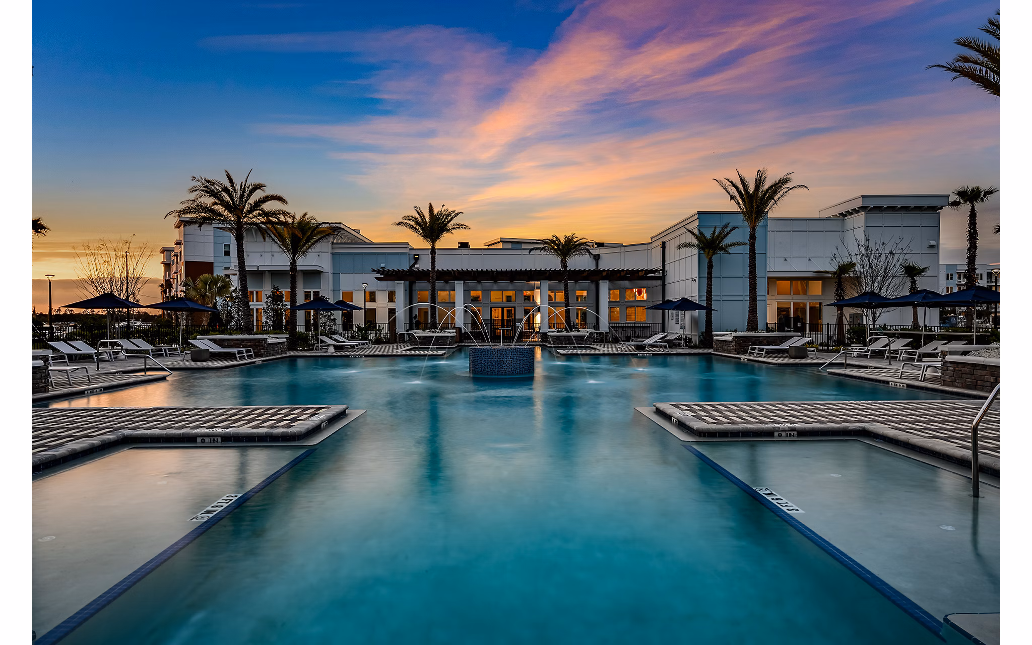 Resort-style pool with lounge chairs at Aspire at Silverleaf Apartments, offering luxury living in a serene setting