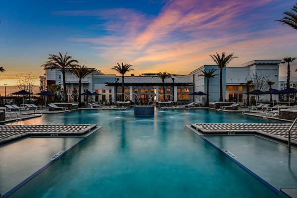 Resort-style pool with lounge chairs at Aspire at Silverleaf Apartments, offering luxury living in a serene setting