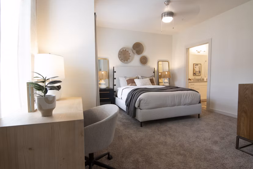 Cozy bedroom with neutral tones and large windows at Sage North Apartments