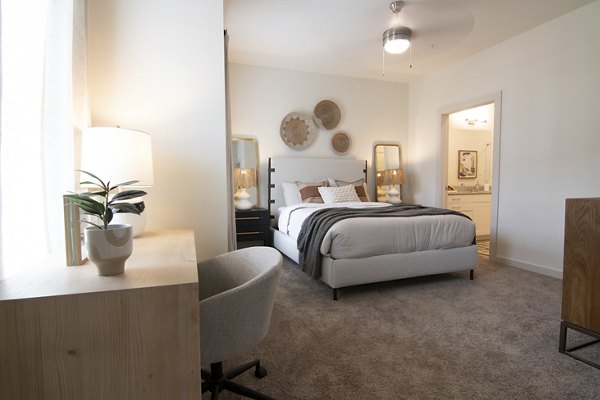 Cozy bedroom with neutral tones and large windows at Sage North Apartments