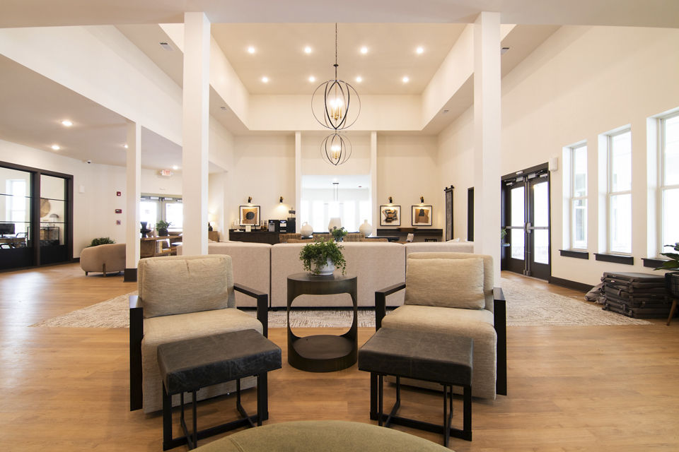 Sage North Apartments: Elegant clubhouse with modern furnishings and ample seating, ideal for social gatherings and events in premium amenities