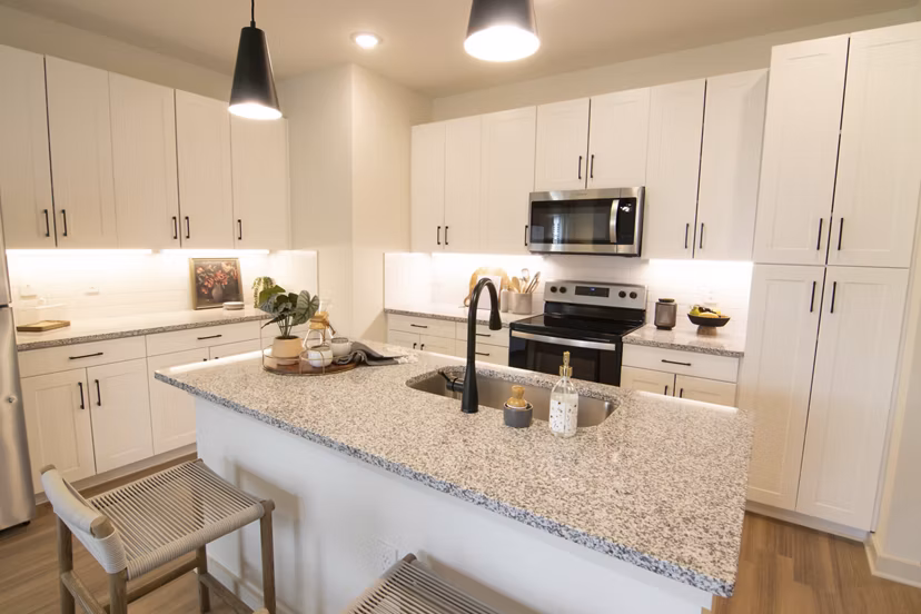 Modern kitchen with sleek cabinetry and stainless steel appliances in Sage North Apartments