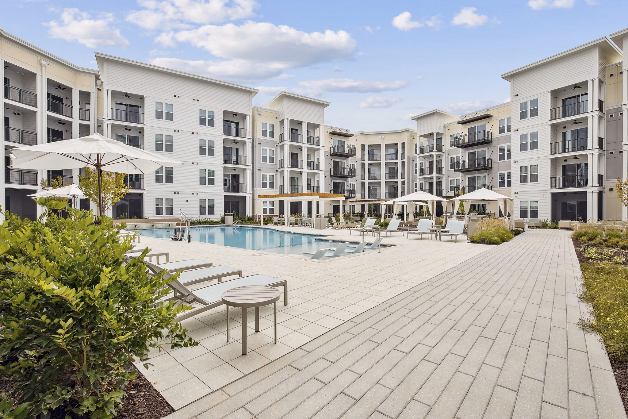 Outdoor swimming pool at 3500 West View Apartments with luxury lounge chairs and scenic views
