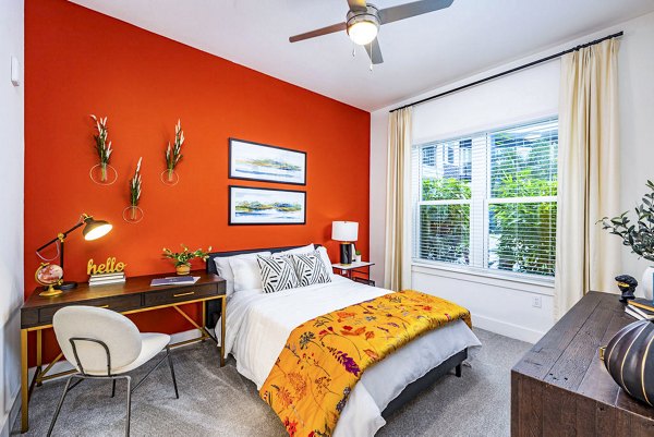 Cozy bedroom with modern decor at Legacy Encore Apartments featuring plush bedding and natural light ambiance