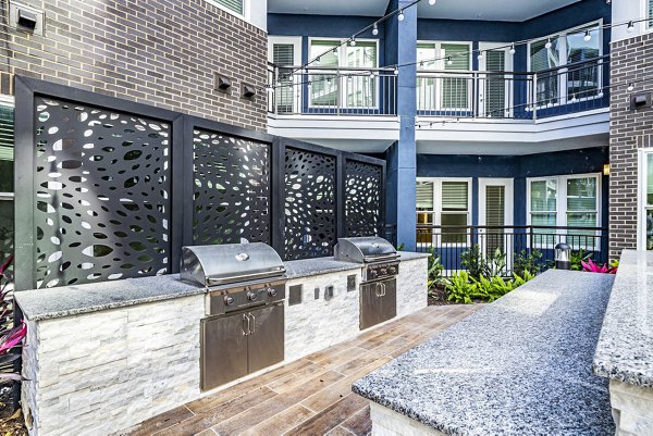 Outdoor grill area with sleek seating at Legacy Encore Apartments