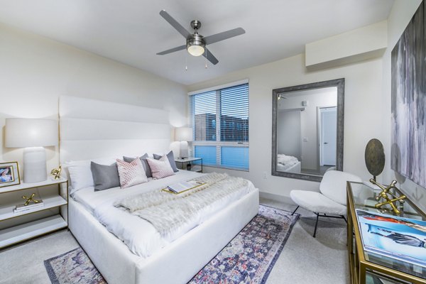 Cozy bedroom featuring modern decor and large windows at Aliso Apartments