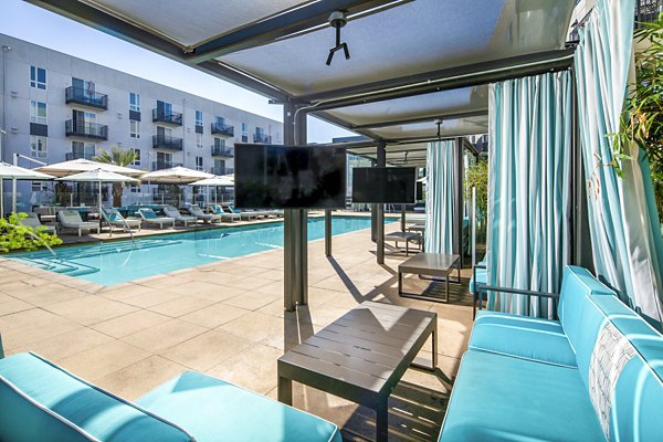 Private poolside cabanas with comfortable seating at Aliso Apartments, perfect for relaxation and luxury living