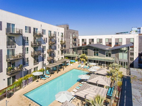 Resort-style pool with palm trees at Aliso Apartments, a luxury property managed by Greystar in sunny Orange County