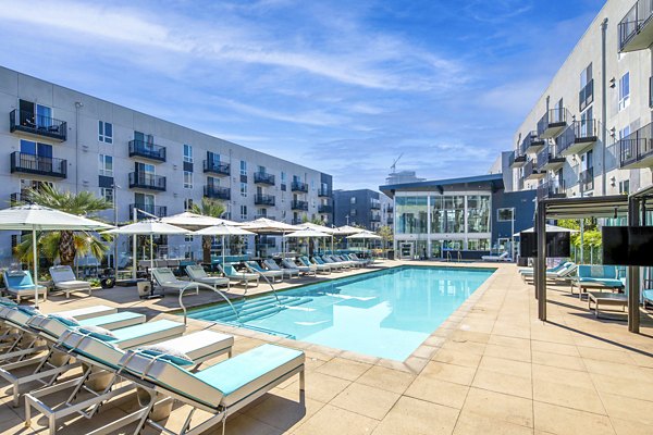 Luxurious pool area with sun loungers at Aliso Apartments