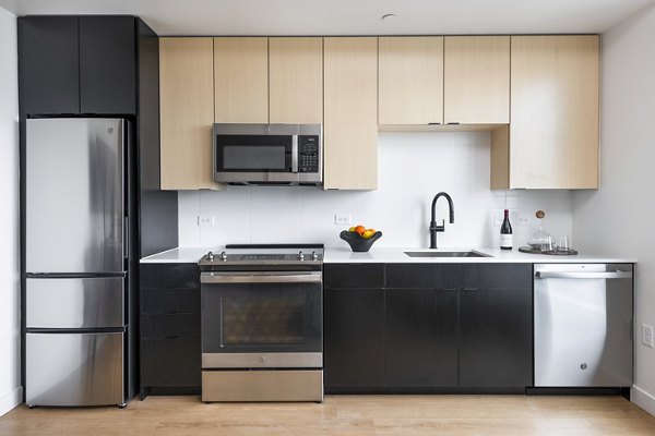 Modern kitchen with stainless steel appliances at FoundryLine Apartments