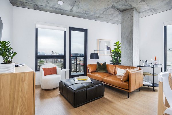 Contemporary living room with sleek furnishings and large windows at FoundryLine Apartments