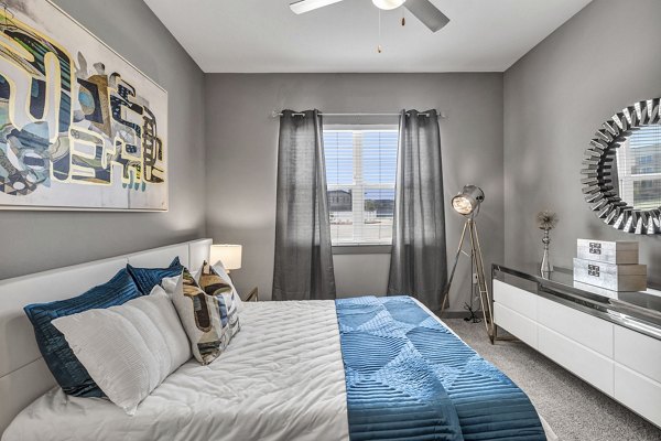 Cozy bedroom with elegant decor at Haven at Mansfield Apartments, featuring plush bedding and ample natural light