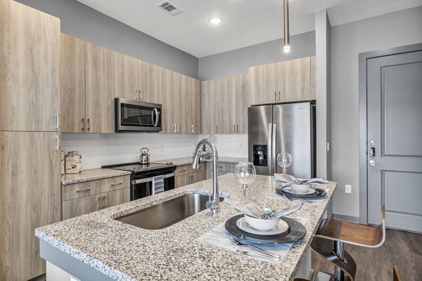 Modern kitchen featuring stainless steel appliances and granite countertops in Haven at Mansfield Apartments