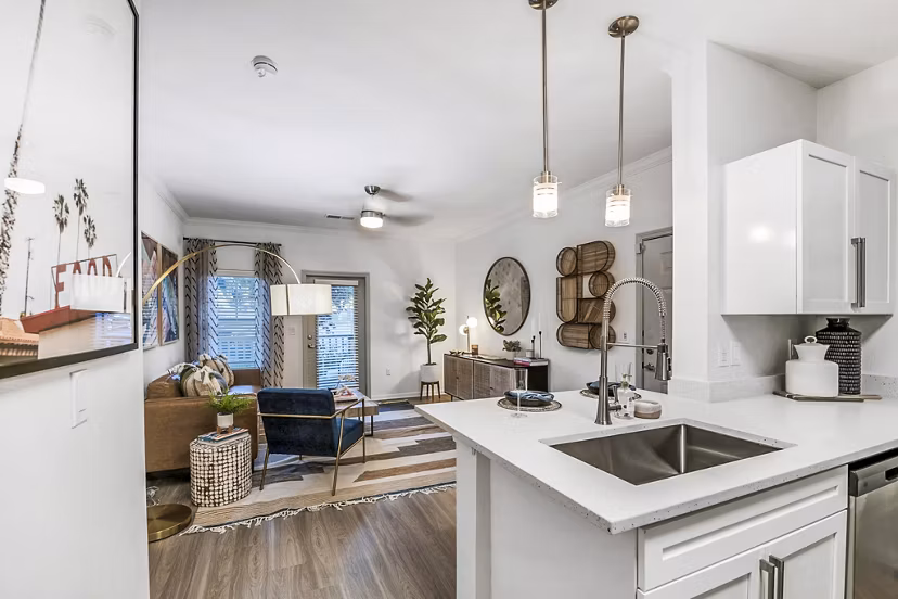 Open-concept kitchen with modern appliances and sleek countertops in Aventura Clear Creek Apartments luxury living