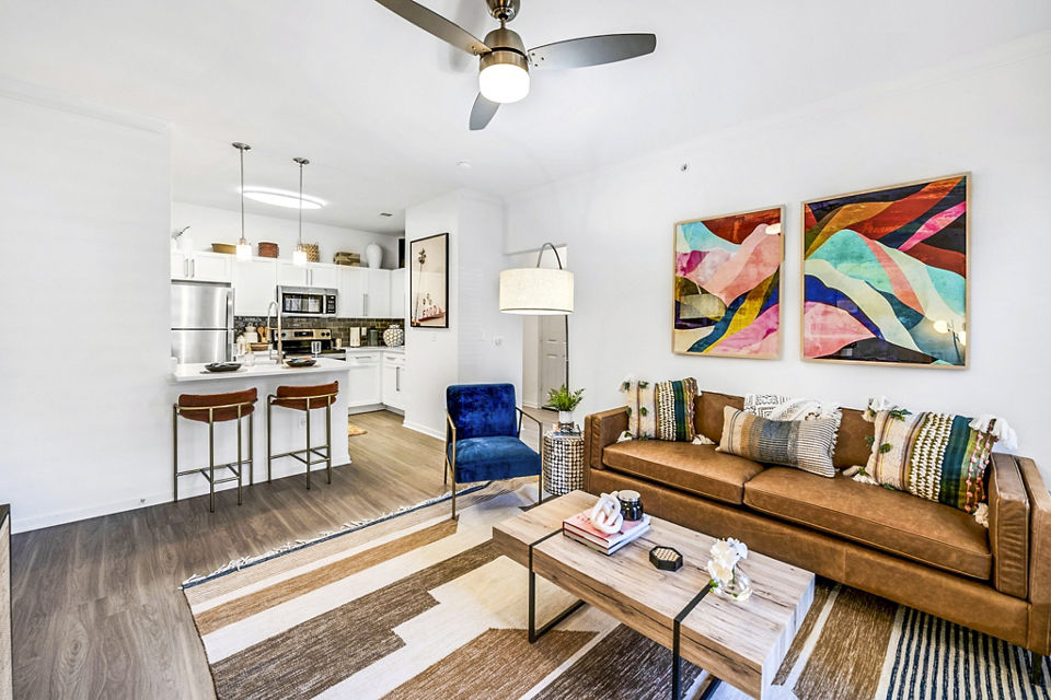 Modern living room with cozy seating and natural light at Aventura Clear Creek Apartments