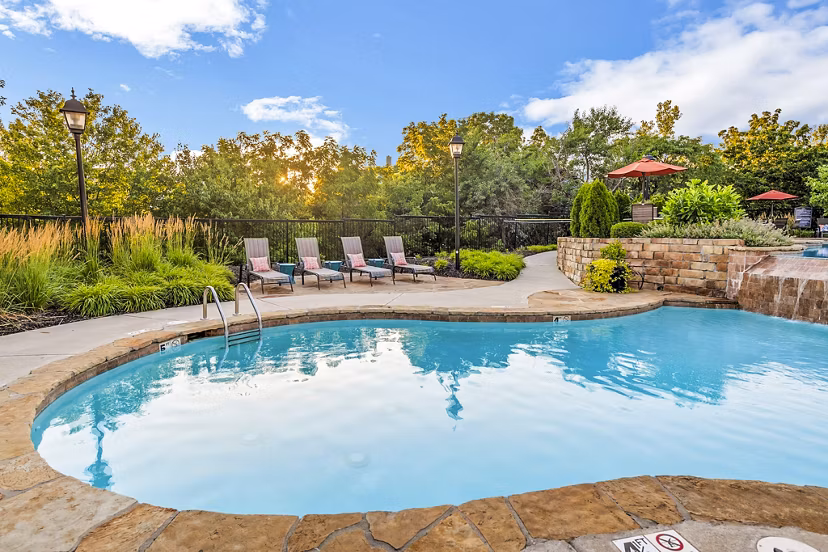 Resort-style pool with palm trees at Aventura Clear Creek Apartments, offering a relaxing oasis for residents