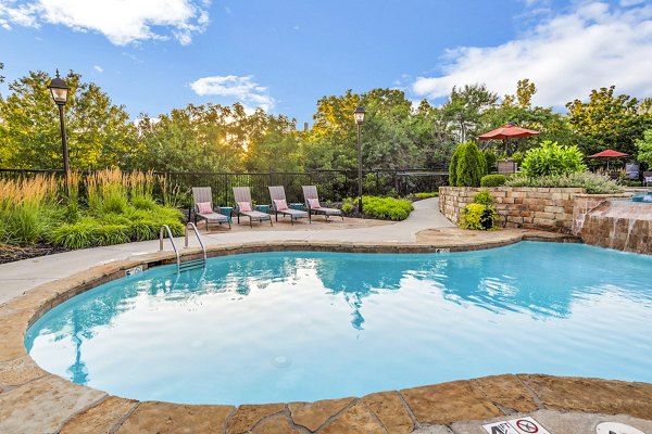 Resort-style pool with palm trees at Aventura Clear Creek Apartments, offering a relaxing oasis for residents